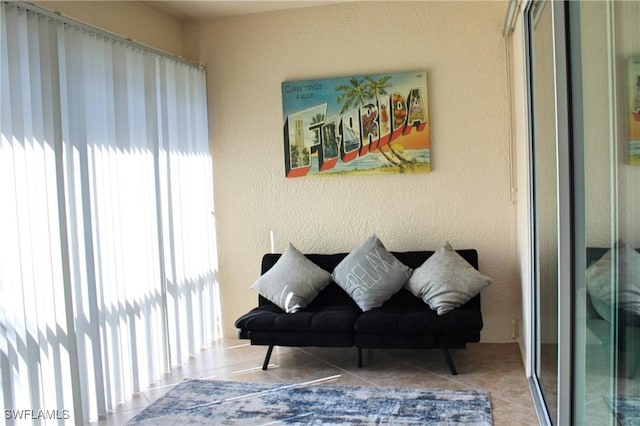 sitting room featuring tile patterned flooring and a textured wall