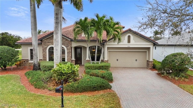 view of front facade featuring stone siding, decorative driveway, an attached garage, and stucco siding