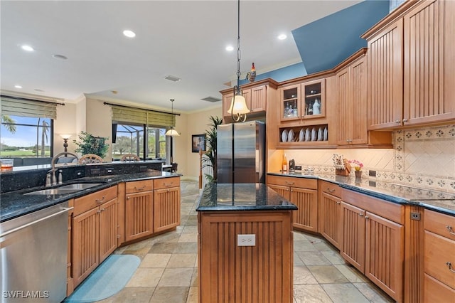 kitchen with tasteful backsplash, dark stone counters, stainless steel appliances, crown molding, and a sink