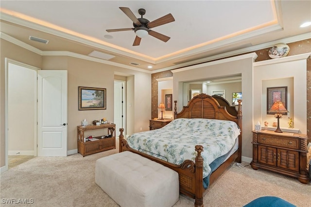 bedroom with carpet floors, visible vents, a raised ceiling, and ornamental molding