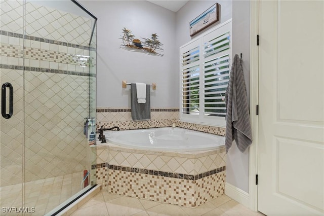 bathroom with tile patterned flooring, a bath, and a shower stall