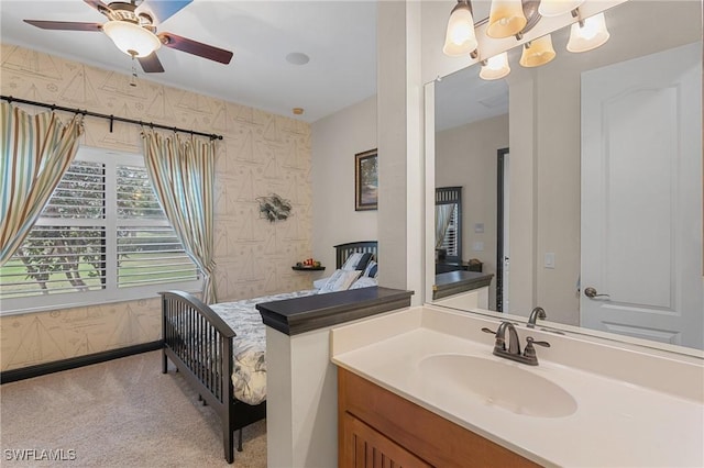 bathroom featuring ceiling fan with notable chandelier, vanity, and wallpapered walls