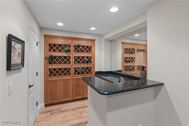 wine area featuring light wood-style floors, wet bar, and recessed lighting