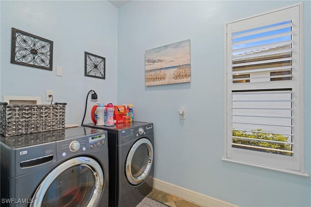 laundry area featuring laundry area, washing machine and dryer, and baseboards