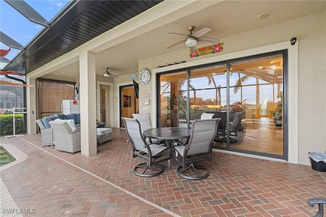 view of patio / terrace featuring glass enclosure, ceiling fan, and an outdoor hangout area