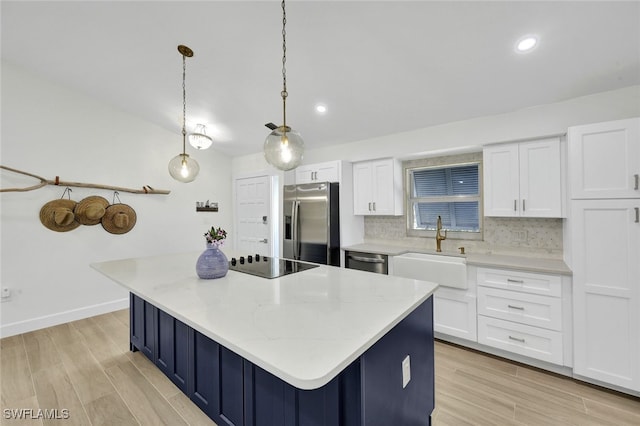 kitchen featuring a sink, white cabinets, backsplash, and stainless steel appliances