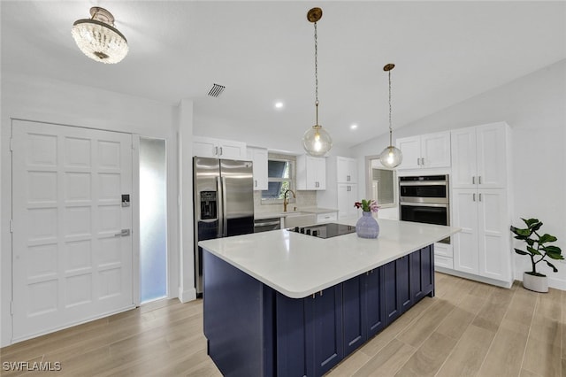 kitchen with light wood-style flooring, a sink, light countertops, appliances with stainless steel finishes, and white cabinetry