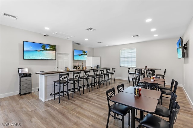 dining room featuring light wood-type flooring, visible vents, and baseboards