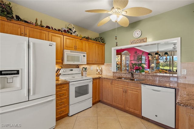 kitchen with white appliances, tasteful backsplash, light tile patterned floors, stone counters, and a sink