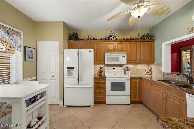 kitchen with white appliances, a healthy amount of sunlight, a sink, and light tile patterned floors