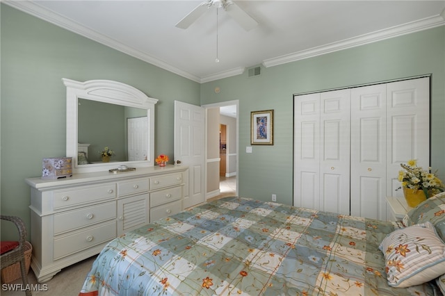 carpeted bedroom featuring ceiling fan, a closet, visible vents, and crown molding