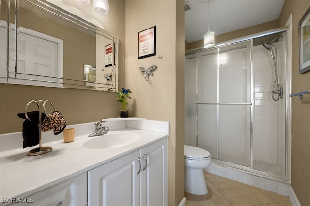 bathroom with visible vents, toilet, a stall shower, vanity, and tile patterned flooring