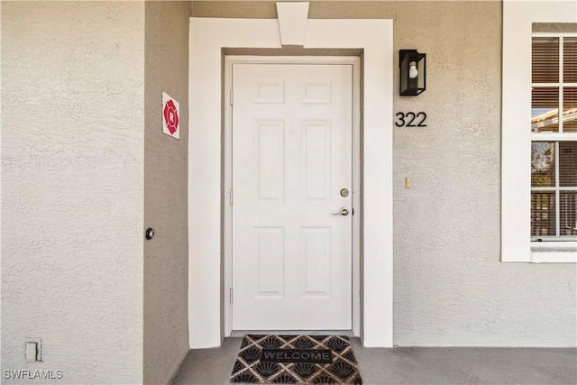 entrance to property featuring stucco siding