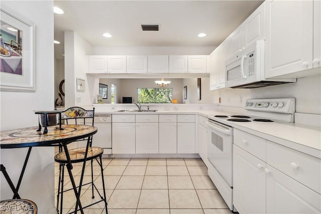 kitchen featuring white appliances, light tile patterned floors, visible vents, and light countertops