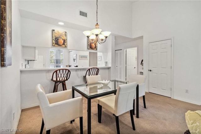 dining room featuring baseboards, visible vents, a towering ceiling, carpet floors, and a notable chandelier