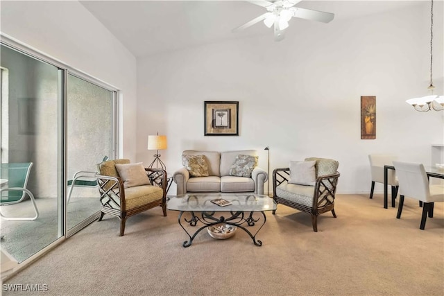 carpeted living area featuring ceiling fan with notable chandelier and high vaulted ceiling