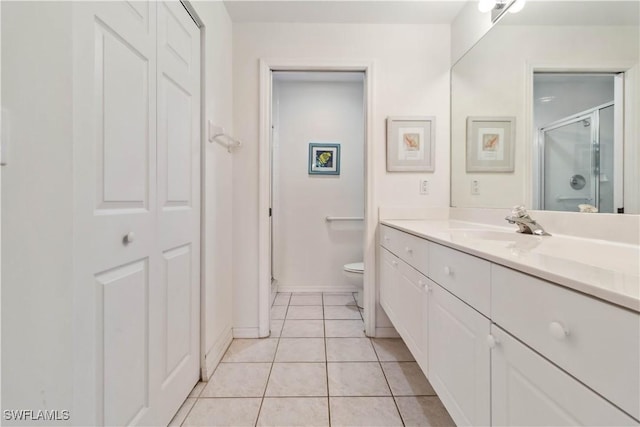 full bath featuring toilet, vanity, baseboards, a shower stall, and tile patterned floors