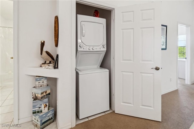 laundry area with stacked washer and dryer, carpet, tile patterned flooring, and laundry area