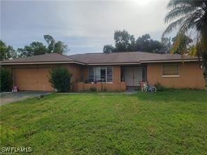 single story home featuring aphalt driveway, a front yard, and a garage