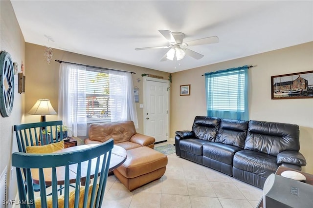 living area with light tile patterned flooring, plenty of natural light, and ceiling fan