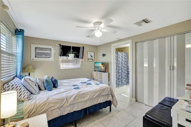 bedroom featuring light tile patterned floors, an AC wall unit, multiple windows, and visible vents