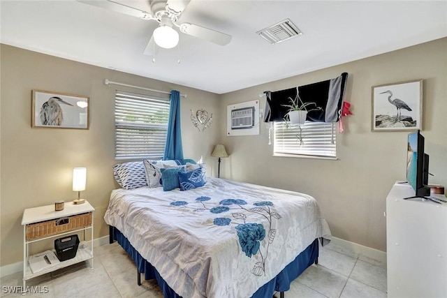 bedroom with an AC wall unit, visible vents, baseboards, and tile patterned floors