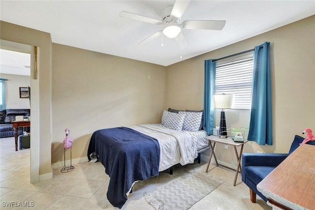 tiled bedroom with ceiling fan and baseboards