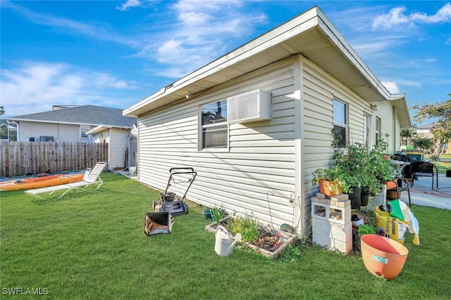 view of side of home with fence and a yard