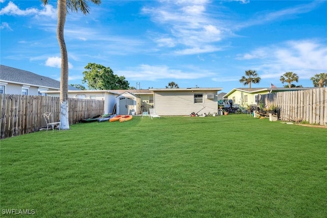 back of house featuring an outbuilding, a fenced backyard, a yard, and a shed