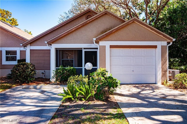 view of front of house featuring a garage, cooling unit, concrete driveway, and stucco siding