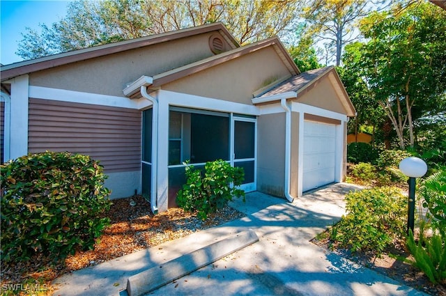 view of property exterior featuring a garage, concrete driveway, and stucco siding