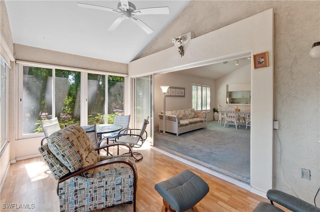 sunroom / solarium with a ceiling fan and vaulted ceiling