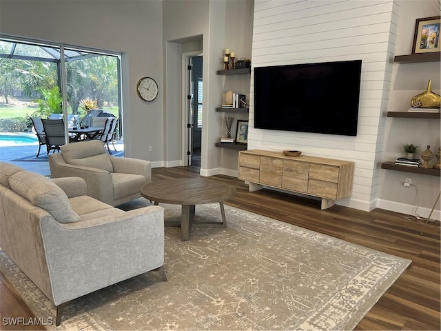 living area with baseboards and wood finished floors