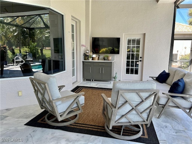 view of patio with glass enclosure and an outdoor living space