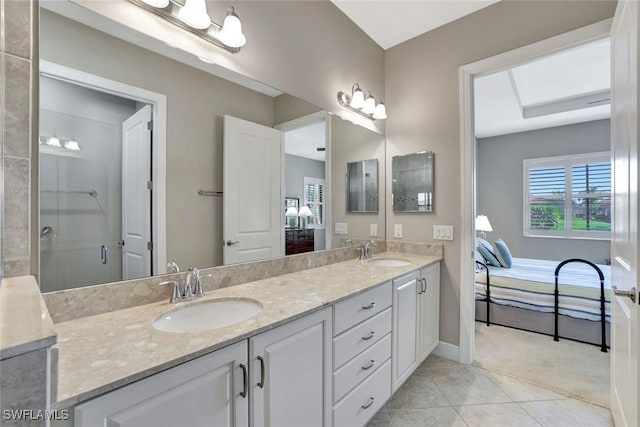 bathroom with double vanity, tile patterned flooring, a sink, and a shower with shower door