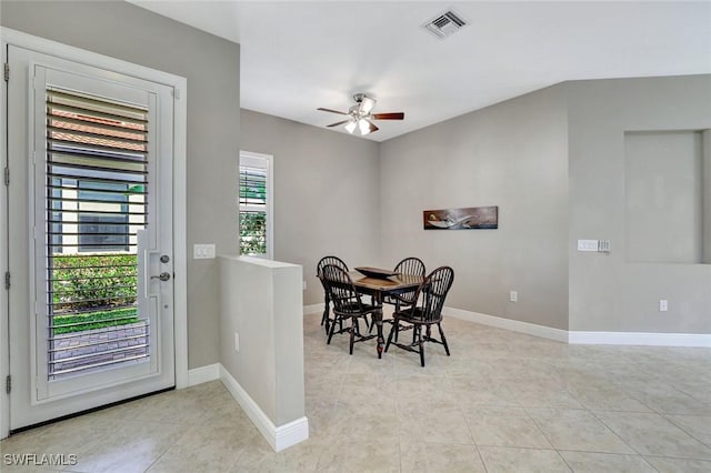 dining room featuring light tile patterned floors, a ceiling fan, visible vents, and baseboards