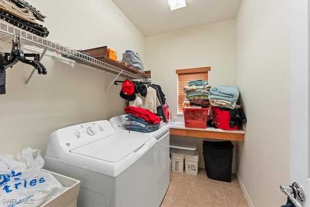 laundry area with washing machine and dryer, laundry area, baseboards, and light tile patterned floors