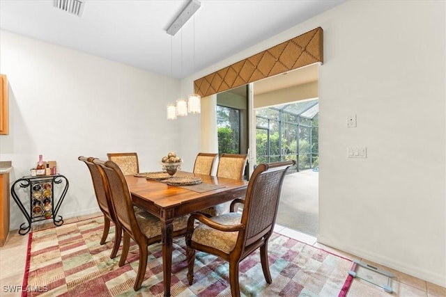 dining area featuring a sunroom, baseboards, and visible vents