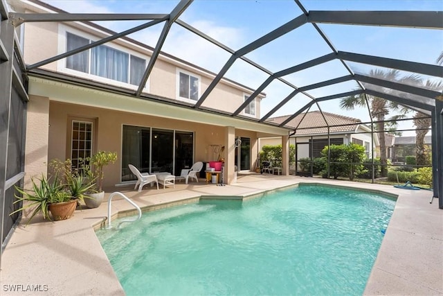 pool featuring glass enclosure and a patio