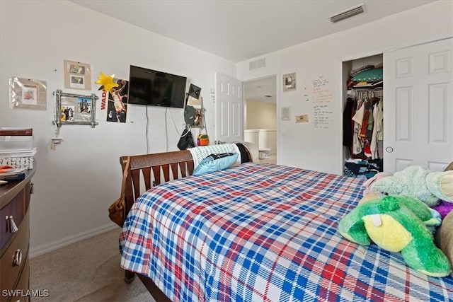 carpeted bedroom featuring a closet, visible vents, and baseboards