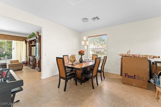 dining area featuring light tile patterned floors, baseboards, visible vents, and a wealth of natural light