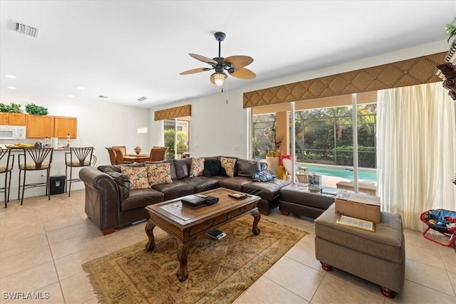 living room with light tile patterned floors, visible vents, and a ceiling fan