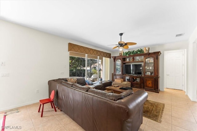 living area featuring light tile patterned floors, baseboards, visible vents, and a ceiling fan