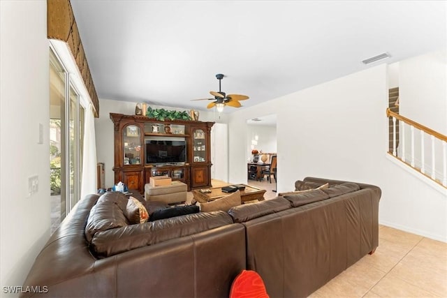 living room with visible vents, baseboards, ceiling fan, stairs, and light tile patterned flooring