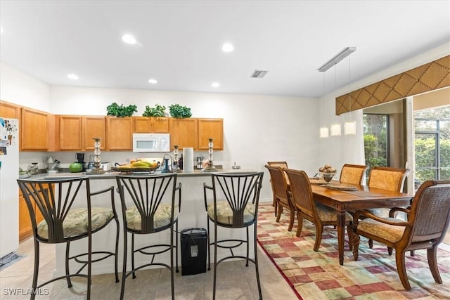 kitchen with light tile patterned floors, white appliances, visible vents, and recessed lighting