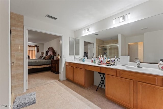 bathroom with double vanity, a stall shower, connected bathroom, tile patterned floors, and a sink