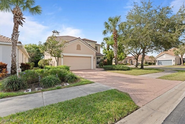 view of front facade with a garage, decorative driveway, and stucco siding