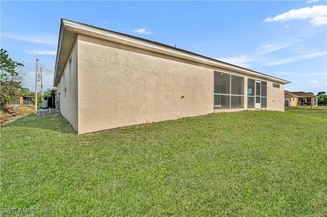 back of property with a lawn and stucco siding