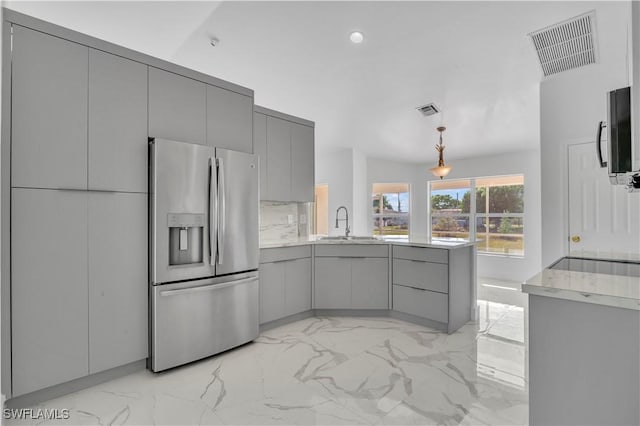 kitchen featuring marble finish floor, stainless steel refrigerator with ice dispenser, gray cabinetry, and a peninsula