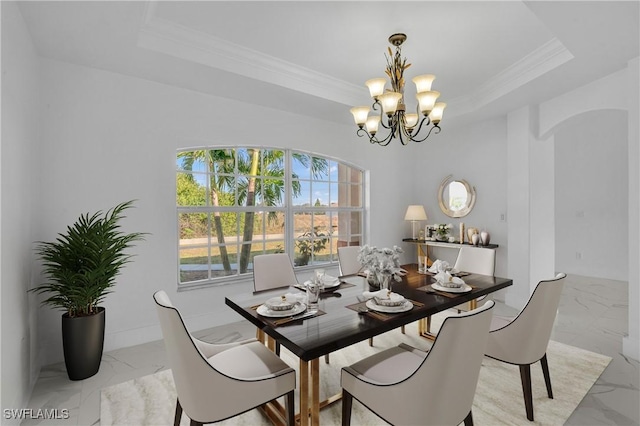 dining area featuring a chandelier, marble finish floor, a raised ceiling, and ornamental molding